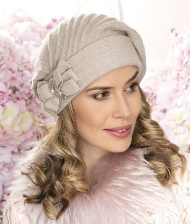 Caciula de dama tip bereta eleganta Tres se evidentiaza prin cusaturile decorative, marginea lata din tricot dublu si fundita stilizata aplicata in lateral.